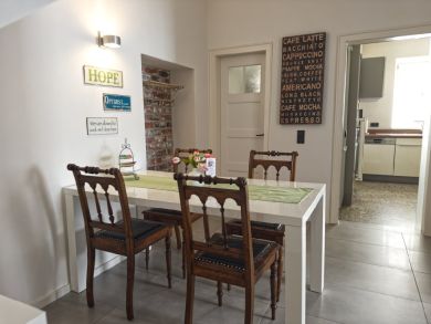 Flur und Essbereich mit weißem Tisch und 4 Holzstühlen