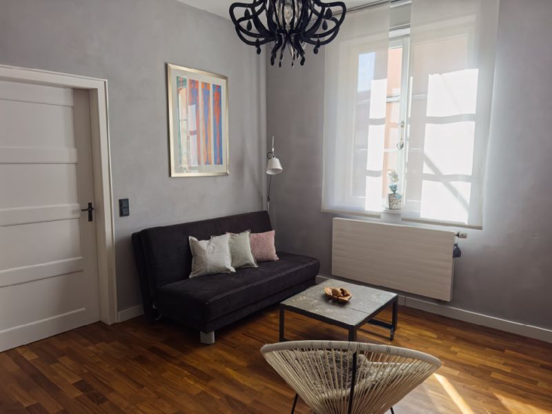 Helles Wohnzimmer mit Sofa, Couchtisch und großem Fenster