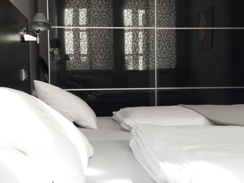 Schlafzimmer 2 mit Doppelbett vor schwarzem Kleiderschrank.